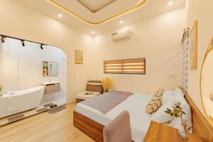 Un dormitorio con una cama, una bañera y un lavabo. en Flex Home, en Da Nang