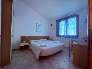 a bedroom with a bed with two towels on it at Residence Il Borgo di Porto Corallo in Villaputzu +104 photos