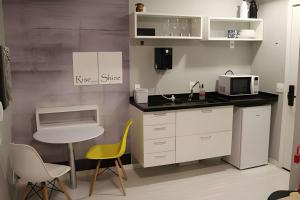 una piccola cucina con una sedia gialla e un microonde di tampopo · urbe Barra Funda, AC, colado no metrô a San Paolo