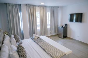a room with a bed and a couch and windows at Davé Paradise in Cartagena de Indias