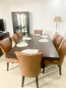 a dining room table with brown chairs around it at Luxurious 3-Bedroom Apartment with a swimming pool in Dakar