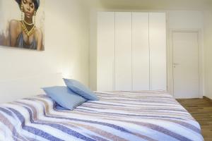 a bedroom with a bed with blue pillows and a painting at Elegante appartamento in Centro storico - Vista sul corso principale - Spazioso , WiFi veloce, posizione top in Pordenone +20 photos