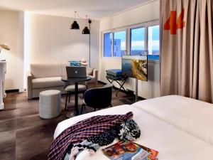 サン・ナゼールにあるibis Styles Saint Nazaire Centre Gareのベッドとソファとテレビがあるホテルの部屋