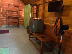 Habitación con TV y mesa con ventilador. en Sigiriya Ranasinghe Nature Villa & Cabana, en Sigiriya