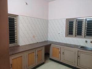 a kitchen with wooden cabinets and a sink and windows at The Ultimate stay in Puducherry