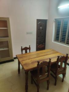 a wooden table and two chairs in a room at The Ultimate stay in Puducherry