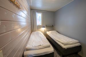 een kleine kamer met twee bedden en een raam bij Ski Center Alpine Houses A5 in Levi