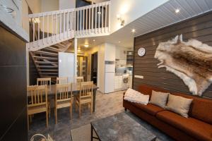 een woonkamer met een bank en een trap bij Ski Center Alpine Houses A5 in Levi