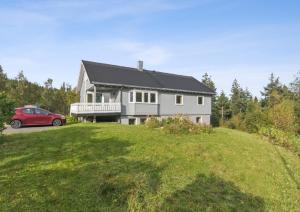 波多Huset i skogskanten i Bodø的前面有一辆红色汽车的房屋