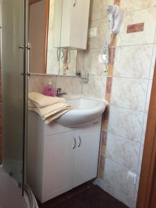 uma casa de banho com um lavatório branco e um chuveiro em Guest House Navetta 2 em Fažana