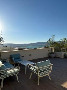 a patio with chairs and tables on a roof at Vista lake - Kinneret view in Tel Kazir