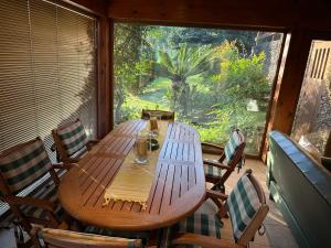 einen Holztisch und Stühle in einem Zimmer mit Fenster in der Unterkunft Chalé do Pinheiro in Vila Nova de Cerveira