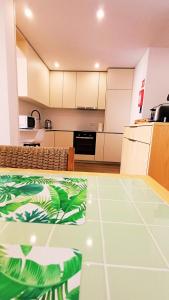 une cuisine avec des armoires blanches et un sol vert dans l'établissement Refúgio Brisa Mar, à Vila do Conde 13 autres photos