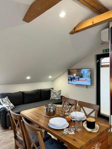 a dining room with a table and a couch at BeeWood apartment in Križe