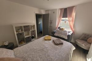 a bedroom with a bed and a couch and a window at Apt - Sleeps 4 5 - Garden - Parking in Margate