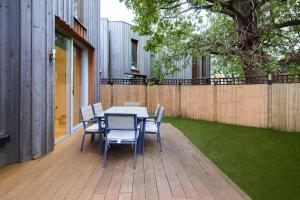 una mesa y sillas en un patio con una valla en Mill Hill Mews Home with Garden, en Hendon 17 fotos más
