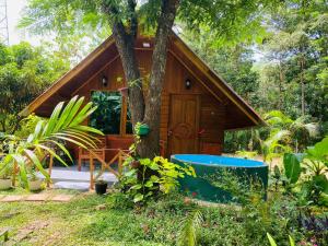 una cabaña en el bosque con un árbol en Sigiriya Ranasinghe Nature Villa & Cabana, en Sigiriya