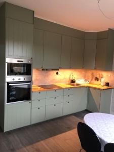 a kitchen with white cabinets and a stove top oven at Sundsvall Timrå Lägenheten in Sundsbruk