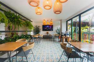 a restaurant with tables and chairs and large windows at Guatapé Country House Hotel in Guatapé