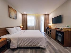 a hotel room with a large bed and a desk at Lâm Viên Hotel & Retreat in Kon Rung (1)