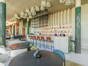un restaurant avec des tables, des chaises et un comptoir dans l'établissement Mercure Tallinn, à Tallinn