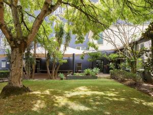 a house with a tree in the yard at Novotel Melbourne Preston in Melbourne