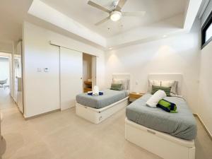 a bedroom with two beds and a ceiling fan at Garden Suite Vista Golf E-105 in Colorado +56 photos