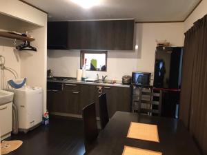 a small kitchen with a black refrigerator and a table at Serenades - Vacation STAY 17875 in Akiruno