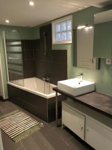 Un baño con lavabo y bañera y un lavabo. en Logement Face Mer, en Audinghen