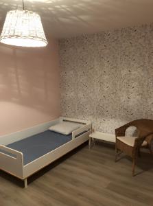 Un dormitorio con una cama, una silla y una lámpara. en Logement Face Mer, en Audinghen