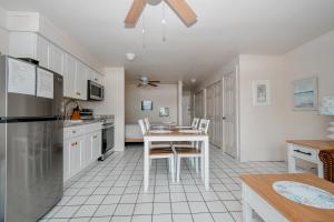 a kitchen with a table and chairs and a refrigerator at Park Place Unit 122 in Cedar Key +4 photos