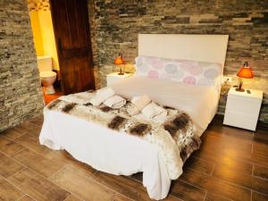 Una cama grande en una habitación con dos lámparas. en Casa Cruz De Tierno, en Vallehermoso