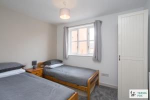a bedroom with two beds and a window at Sarah's House BBQ Parking 10mins To Alton Towers in Rocester
