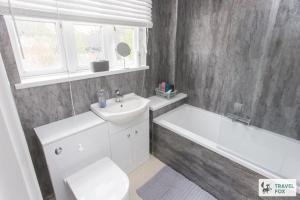 a bathroom with a sink and a tub and a toilet at Sarah's House BBQ Parking 10mins To Alton Towers in Rocester +12 photos