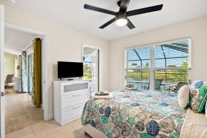 a bedroom with a bed and a flat screen tv at Newley Built Oasis Heated Pool Waterfront retreat in Rotonda West +44 photos