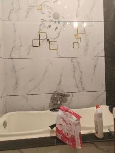 uma casa de banho com uma banheira branca e uma parede de mármore branco em Hotel kamla em Haldwani-cum-Kathgodam