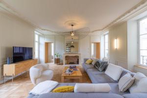 バイユーにあるHistoric 18th-Century Mansion - 3 BR - Bayeux - Garden & Museums Nearbyのソファとテレビのあるリビングルーム