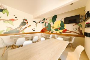 a dining room with a mural of birds on the wall at Villa Oasis in Ica