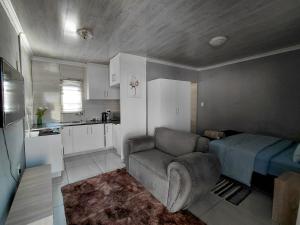 a living room with a couch and a kitchen at Mama R's Budget-friendly BACKROOM 2 in Newcastle