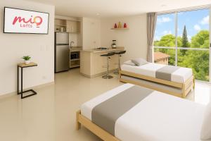 a white room with two beds and a kitchen at Edificio La Frontera - Vista El Poblado Free Parking & Wifi Recep 24 h in Medellín