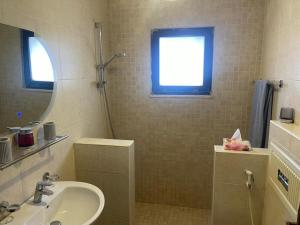 a bathroom with a sink and a shower with a mirror at Jubaiha Stars in Al Jafr