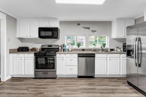 a kitchen with white cabinets and stainless steel appliances at Grill & Chill Retreat in Acworth