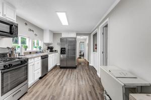 a kitchen with white cabinets and a stainless steel refrigerator at Grill & Chill Retreat in Acworth +28 photos