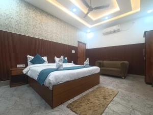 una camera da letto con un letto grande e una sedia di Townhouse Oak Civil Lines Prayagraj Formerly The Grand Palace a Allāhābād Junction