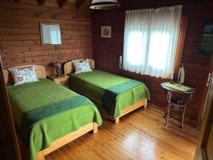 ein Schlafzimmer mit zwei Betten in einer Blockhütte in der Unterkunft Chalé do Pinheiro in Vila Nova de Cerveira + 66 Fotos