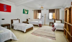 a room with two beds and a rug at Onda Surf in Taghazout