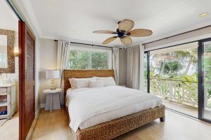 Un dormitorio con una cama y un ventilador de techo. en Kahaone Family Retreat (30+ night rental), en Waialua