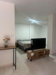a room with a bed and a television on a table at Apartamento Playa Real - San Gil in San Gil