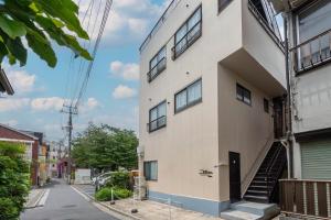 a white building with stairs on the side of it at Sakuraya 2 77m 2LDK 8 minutes to Hirokoji Station in Tokyo