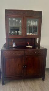 a large wooden cabinet with glass doors at La casa di Emilio in Ponte San Nicolo